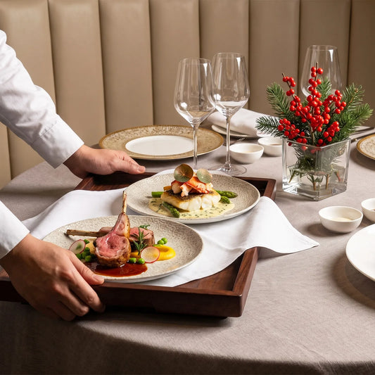 Waiter presenting two plated dishes on a wood serving tray in a hotel restaurant